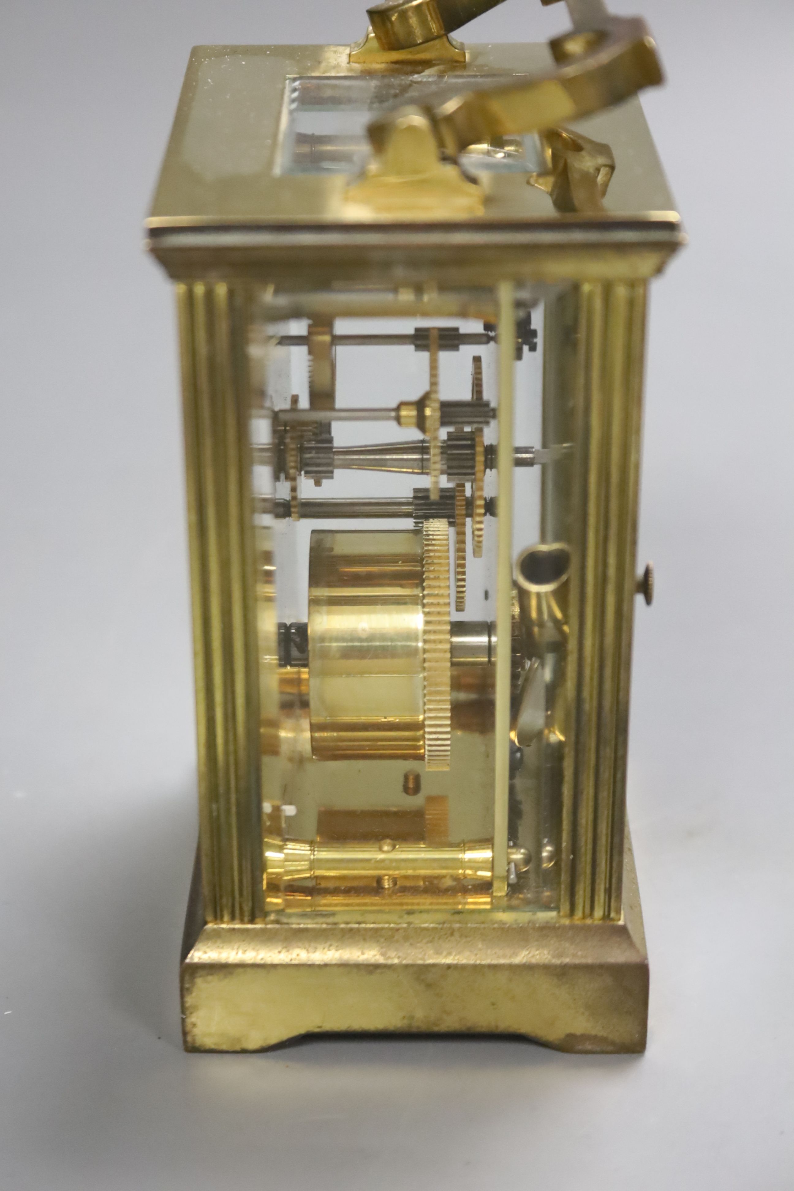 An early 20th century brass carriage timepiece, retailed by Mappin & Webb Ltd, black Roman numerals on a white dial, 8cm wide 15cm high (max.)